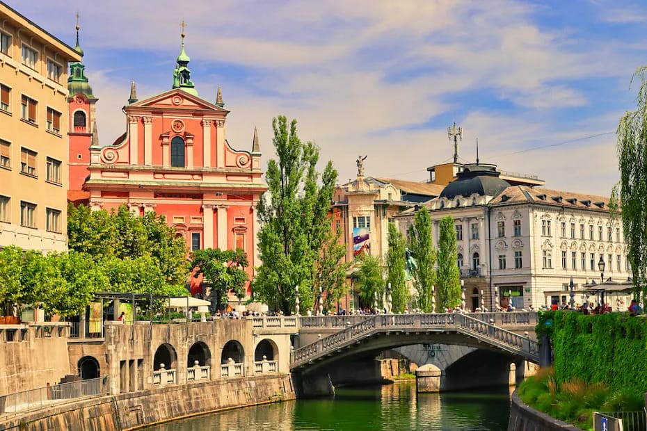 Scenic view of the car-free city center in Ljubljana Slovenia, showing the Triple Bridge and the pink Franciscan Church, ideal for senior travelers.