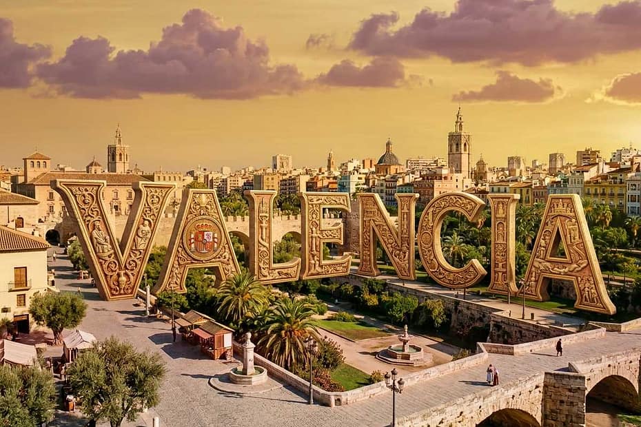 Panoramic view of historic Valencia skyline with a transparent Spanish flag overlay and decorative Valencia typography